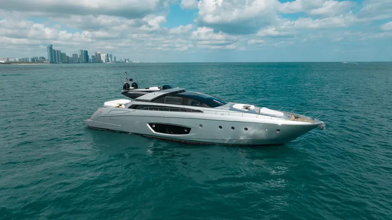 Purosangue Yacht Photos Pics Luxurious 2014 Riva 86' DOMINO yacht cruising near a city skyline under a cloudy sky.