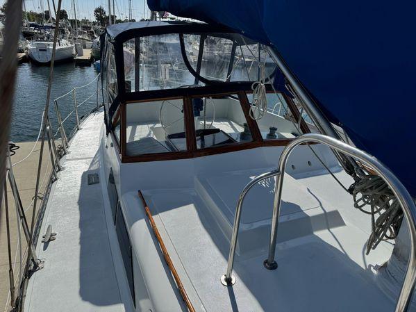 1989 Custom SEA MAID sailboat docked at marina, featuring a sleek deck and blue canopy.