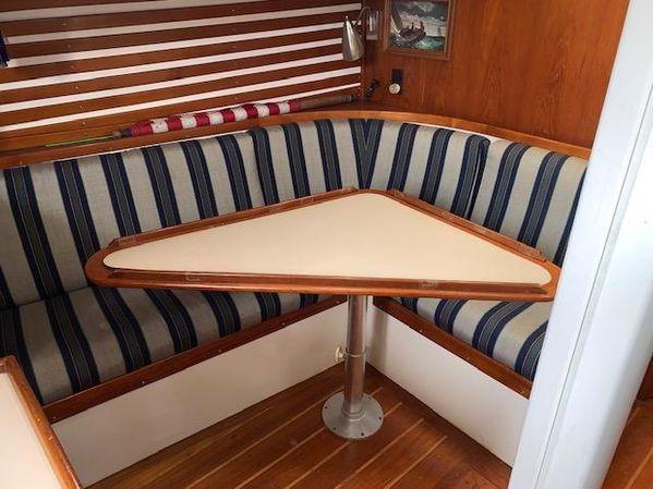 Cozy 1989 Custom SEA MAID boat interior with striped seating and triangular table.