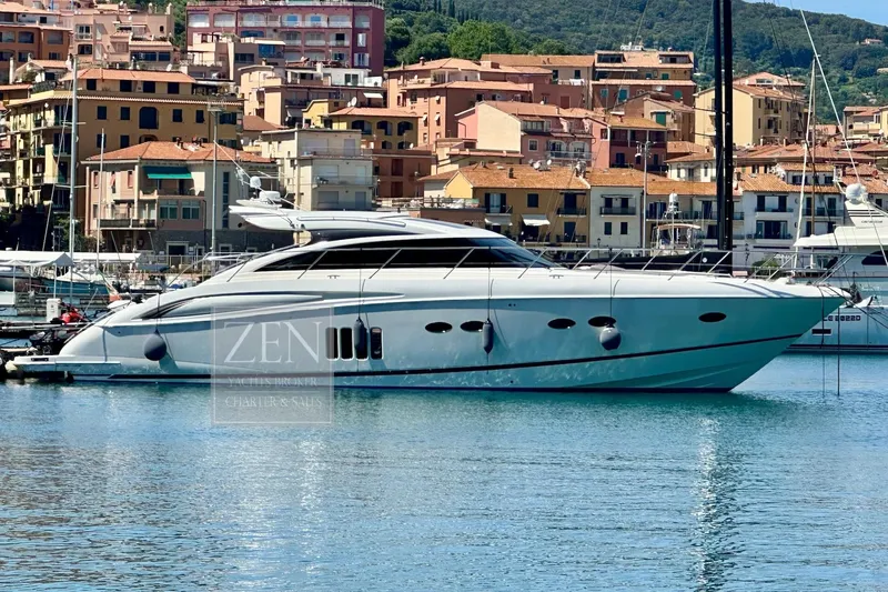  Yacht Photos Pics 2009 Princess V62 yacht docked in a scenic marina with colorful buildings.