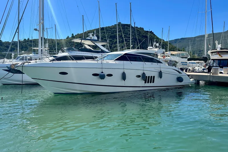  Yacht Photos Pics Luxury 2009 Princess V62 yacht docked in a serene marina setting.