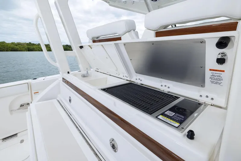  Yacht Photos Pics Manufacturer Provided Image: 2025 Pursuit S 328 Sport boat with onboard grill and sink, docked by water.