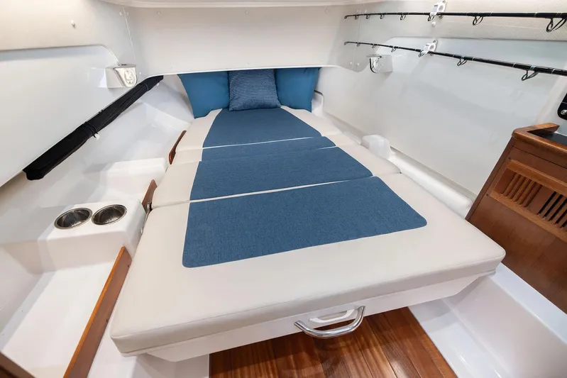  Yacht Photos Pics Manufacturer Provided Image: 2025 Pursuit S 328 Sport cabin interior with blue cushions and wooden accents.