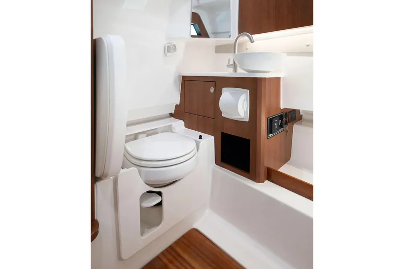  Yacht Photos Pics Manufacturer Provided Image: 2025 Pursuit S 328 Sport boat bathroom with toilet, sink, and wooden cabinetry.