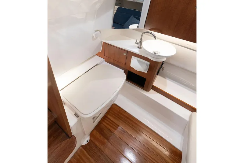  Yacht Photos Pics Manufacturer Provided Image: 2025 Pursuit S 328 Sport boat interior with wooden flooring and compact bathroom amenities.
