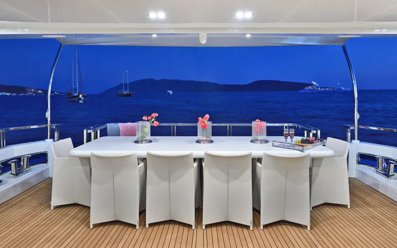 Tortura Yacht Photos Pics 2024 Aegean Yacht Explorer M26 dining area with ocean view at dusk.