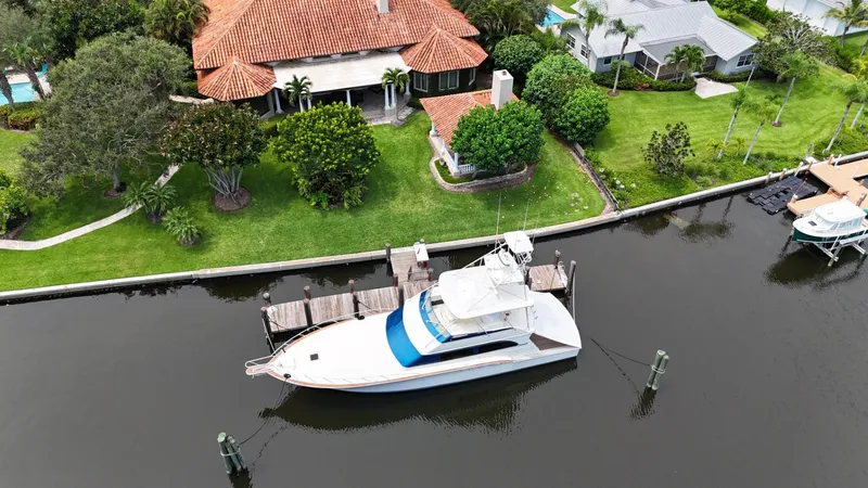  Yacht Photos Pics Aerial view of a 1991 Donzi 65 Sportfisherman docked by a waterfront home.