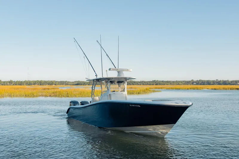  Yacht Photos Pics 2014 Yellowfin 34 Offshore boat on calm water, surrounded by marshland.