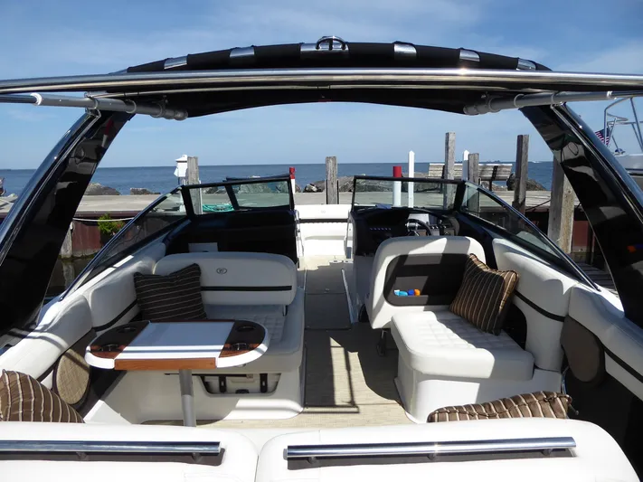 Yacht Photos Pics 2017 Cobalt R30 boat interior with seating and table, docked by the sea.