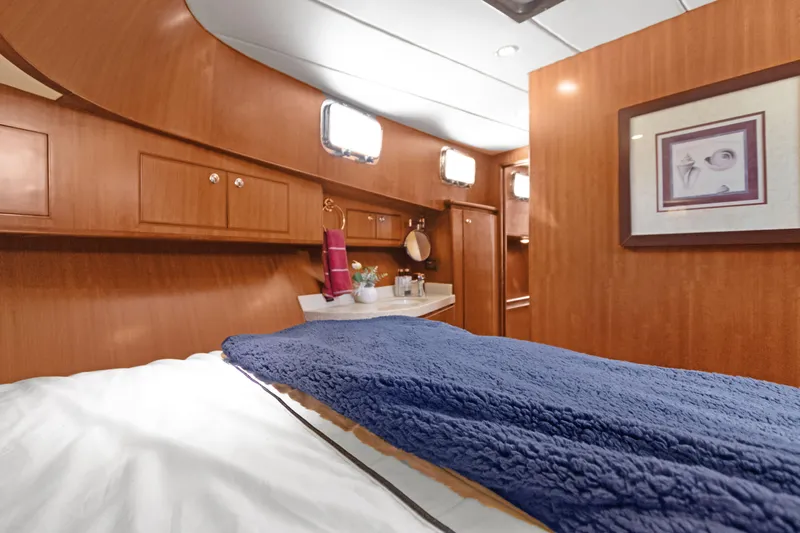  Yacht Photos Pics Luxurious cabin interior of 2006 Noresman 480 Sedan with wood paneling and cozy bedding.