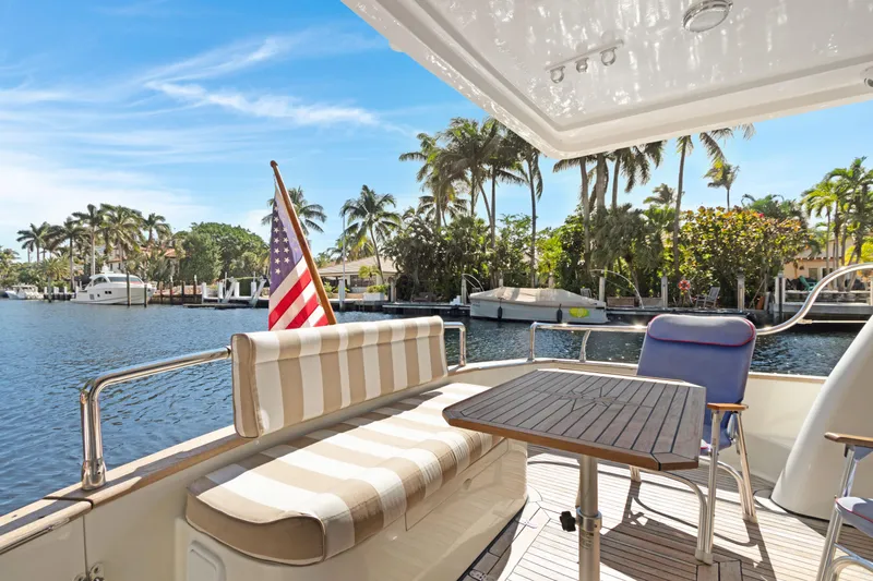  Yacht Photos Pics Luxury Noresman 480 Sedan yacht deck with seating, table, and American flag, 2006 model.