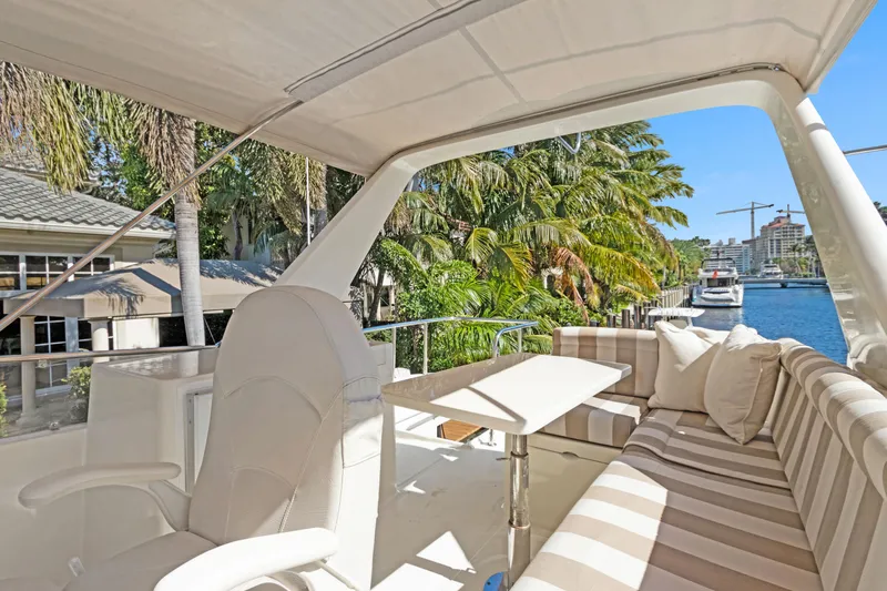 Yacht Photos Pics Luxury Noresman 480 Sedan yacht interior with striped seating, table, and waterfront view.