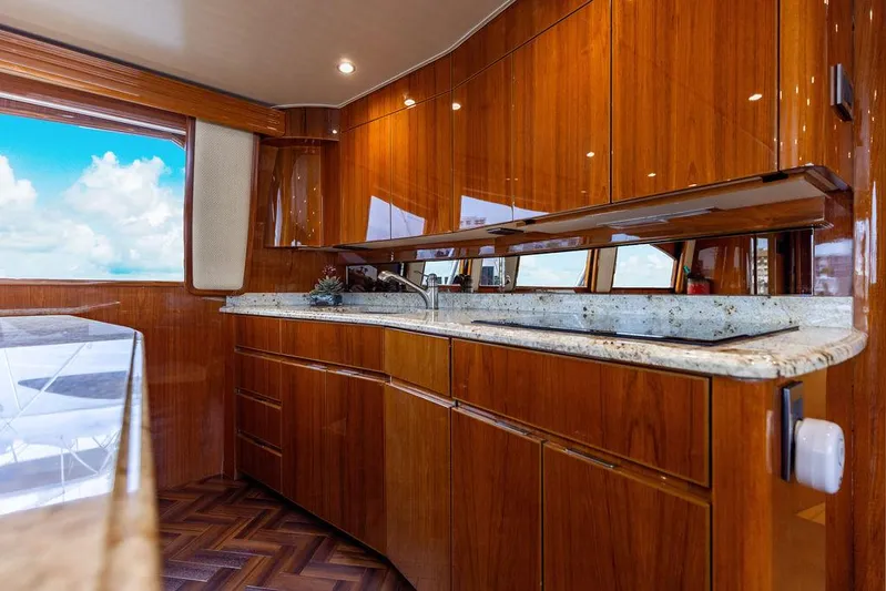 Harbor Time Yacht Photos Pics Luxurious kitchen interior of 2013 Viking 66 Open yacht with wooden cabinets and granite countertops.