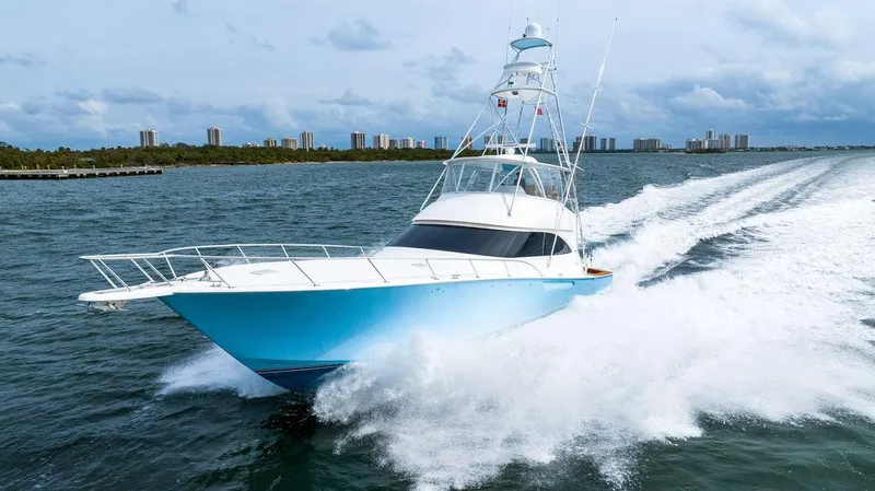 Harbor Time Yacht Photos Pics 2013 Viking 66 Open yacht cruising swiftly on open water, city skyline in background.