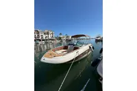 2008 Rinker 228 DB boat docked in a sunny marina with clear blue skies.