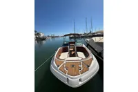 2008 Rinker 228 DB boat docked in a marina under clear blue skies.