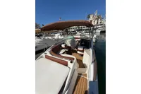 2008 Rinker 228 DB boat with canopy, docked in marina under clear blue sky.