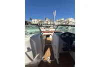 2008 Rinker 228 DB boat interior with dashboard, docked at marina under clear blue sky.