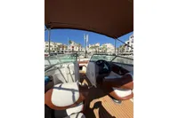 2008 Rinker 228 DB boat interior with brown and white seating, docked in a sunny marina.