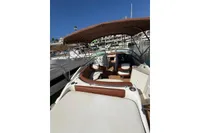 2008 Rinker 228 DB boat with brown seating and canopy, docked in a marina.
