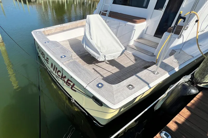 Double Nickel Yacht Photos Pics 1999 Viking 55 yacht docked, featuring spacious deck and covered seating area.