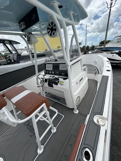 Cobia 254 Yacht Photos Pics 2001 Cobia 254 Center Console boat with modern helm and seating, docked under cloudy skies.