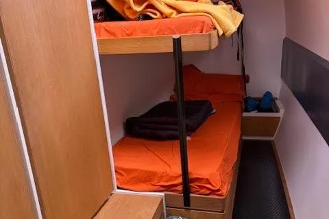 Obi One Yacht Photos Pics Interior cabin of 2009 Catamaran Trimarine Carrera 57 with orange bedding and bunk beds.