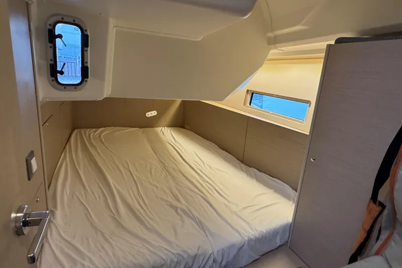 Madras Yacht Photos Pics Cozy cabin interior of 2022 Beneteau Oceanis 40.1 sailboat with bed and porthole windows.