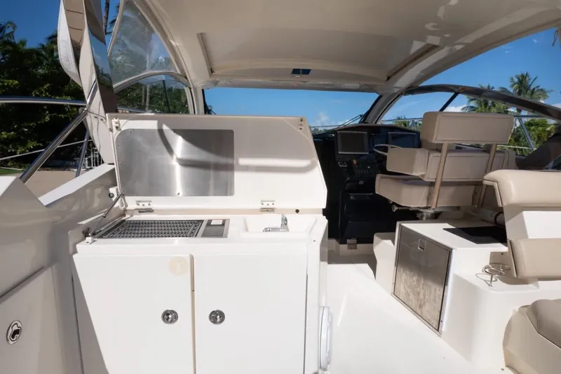  Yacht Photos Pics 2014 Pursuit SC 365i Sport Coupe interior with seating and kitchenette under sunny skies.