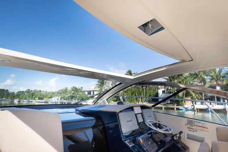  Yacht Photos Pics 2014 Pursuit SC 365i Sport Coupe helm with open roof, overlooking marina and palm trees.