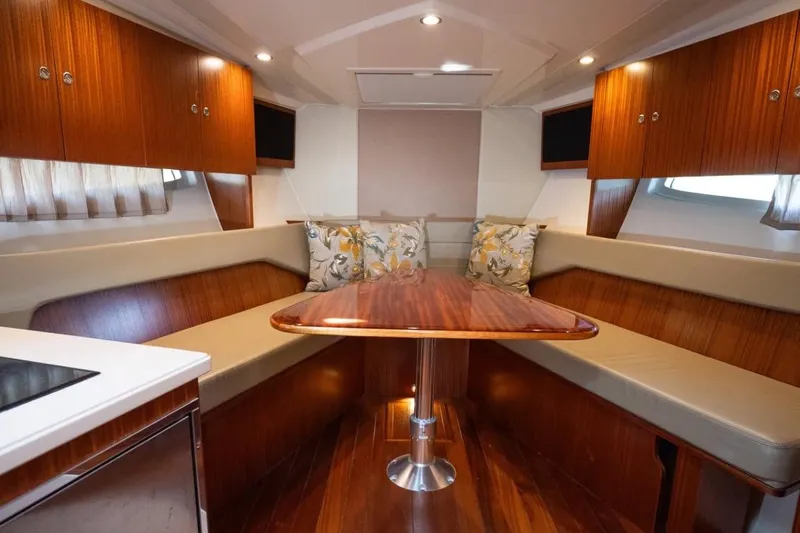  Yacht Photos Pics Luxurious interior of 2014 Pursuit SC 365i Sport Coupe with wood finishes and plush seating.