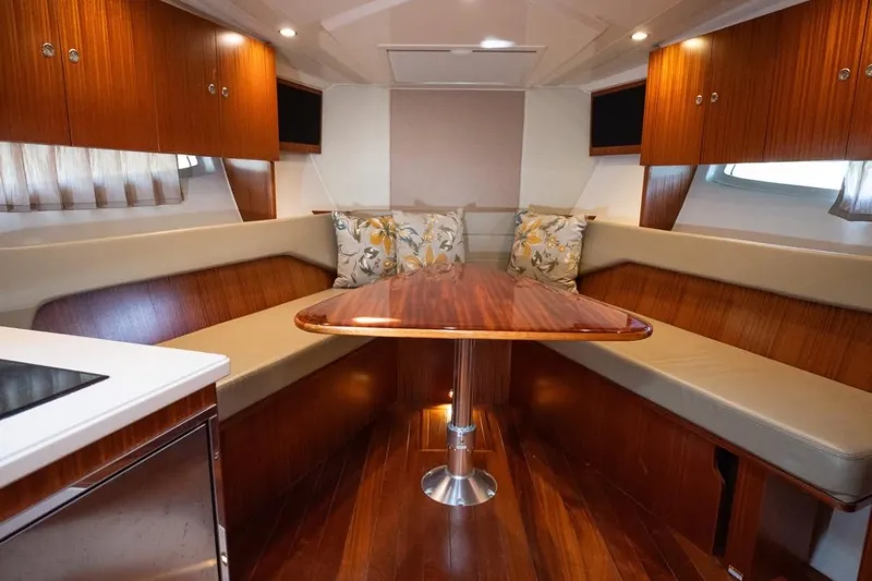  Yacht Photos Pics Luxurious interior of 2014 Pursuit SC 365i Sport Coupe with wood finishes and cozy seating.