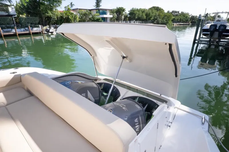  Yacht Photos Pics 2014 Pursuit SC 365i Sport Coupe with open engine compartment, docked by calm waters.