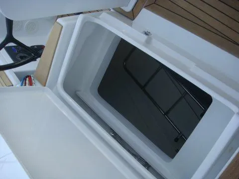 Bonejour Yacht Photos Pics Hanse 385 (2012) yacht cockpit storage compartment with wooden flooring and steering wheel.