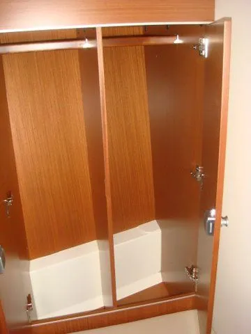Bonejour Yacht Photos Pics Wooden interior cabinet of 2012 Hanse 385 yacht, open doors showing storage space.