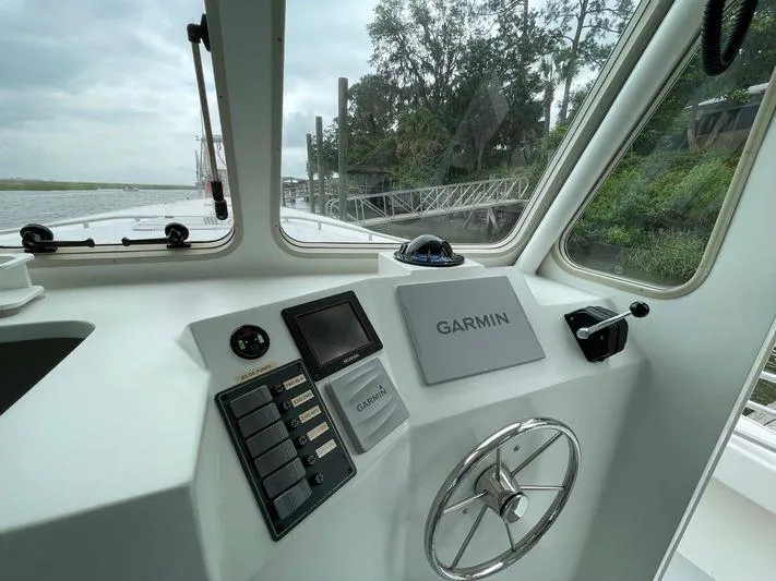  Yacht Photos Pics 2015 Wesmac Sport Fish boat dashboard with Garmin navigation system, steering wheel, and control panel.