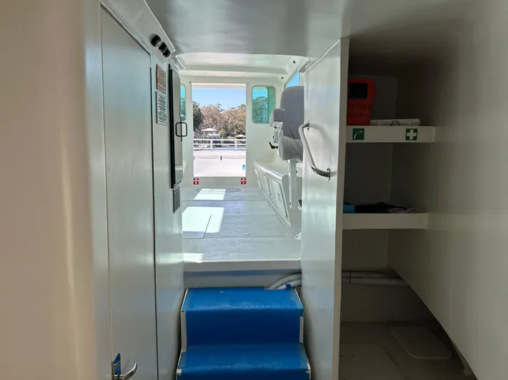  Yacht Photos Pics 2015 Wesmac Sport Fish interior with blue steps, storage shelves, and cockpit view.