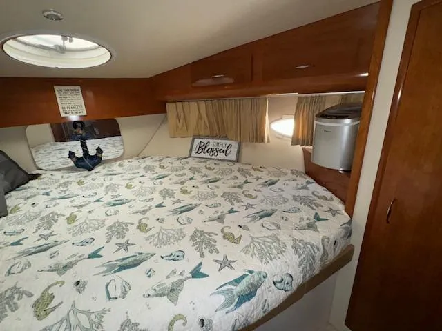 Diversion Yacht Photos Pics Cozy bedroom in 2006 Carver 36 Motor Yacht with nautical-themed bedding and wood cabinetry.