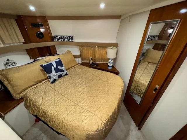 Diversion Yacht Photos Pics 2006 Carver 36 Motor Yacht bedroom with cozy bed, nautical decor, and mirrored closet.