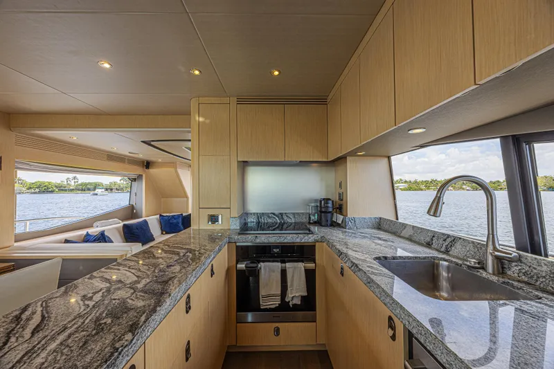 Dirty Dawg Yacht Photos Pics Luxurious kitchen interior of 2017 Sunseeker 75 Yacht with granite countertops and scenic water view.