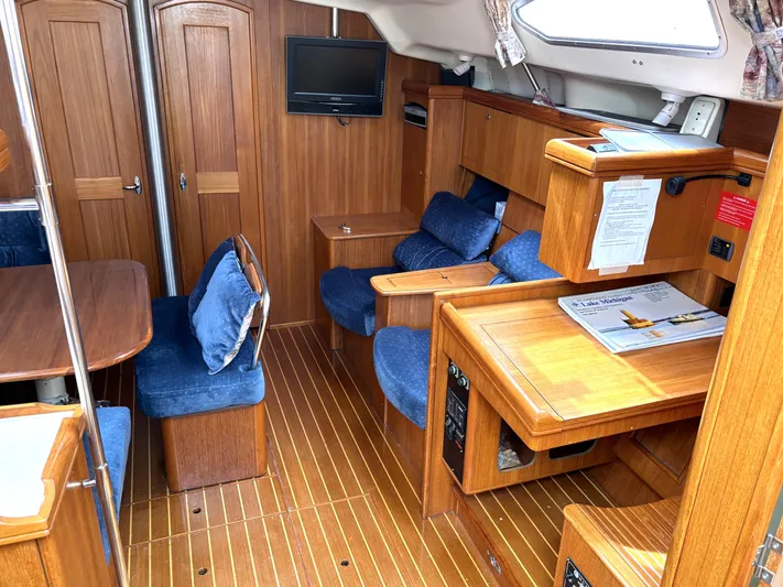 Memories Yacht Photos Pics Interior of 2004 Hunter 466 sailboat with wooden furnishings and blue upholstery.