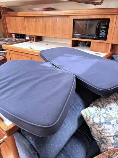 Memories Yacht Photos Pics Interior of a 2004 Hunter 466 yacht with cushions and wooden cabinetry.