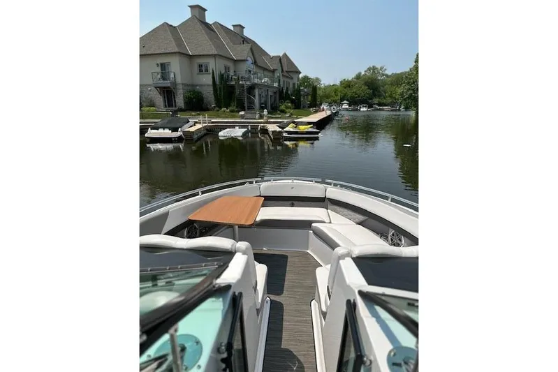  Yacht Photos Pics 2018 Four Winns H350 boat docked near waterfront homes, featuring spacious seating and table.