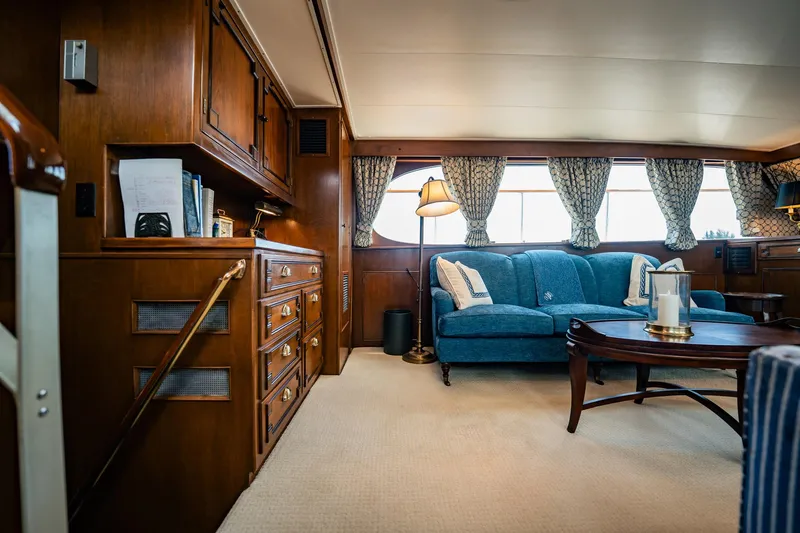 Coconut Yacht Photos Pics Luxurious interior of a 1964 Burger 64' Motor Yacht with elegant wood paneling and blue sofa.