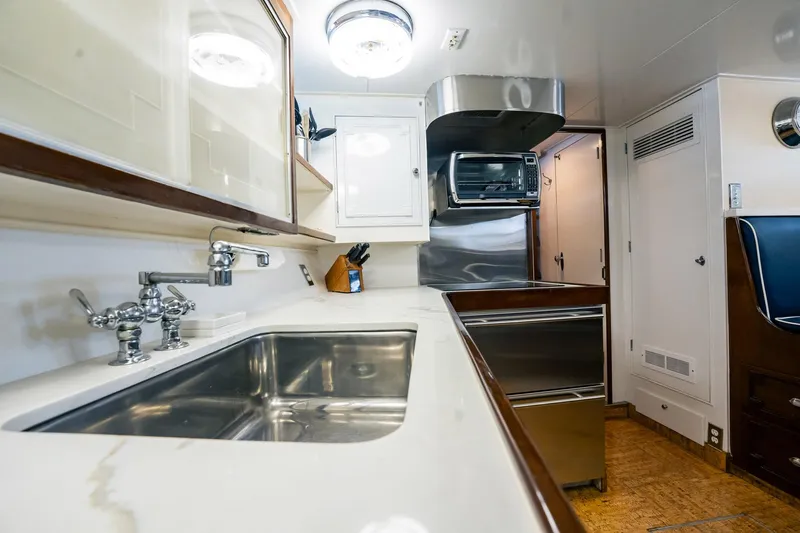 Coconut Yacht Photos Pics Galley kitchen in 1964 Burger 64' Motor Yacht with stainless steel sink and modern appliances.