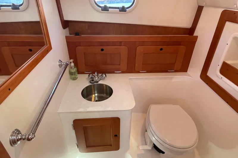 Beyond The Sea Yacht Photos Pics 2017 Hunt Surfhunter 29 boat bathroom with sink, toilet, and wooden cabinetry.