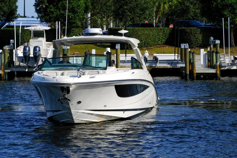 Sensei I Yacht Photos Pics 2021 Sea Ray SLX 400 boat cruising in a marina, surrounded by docks and greenery.