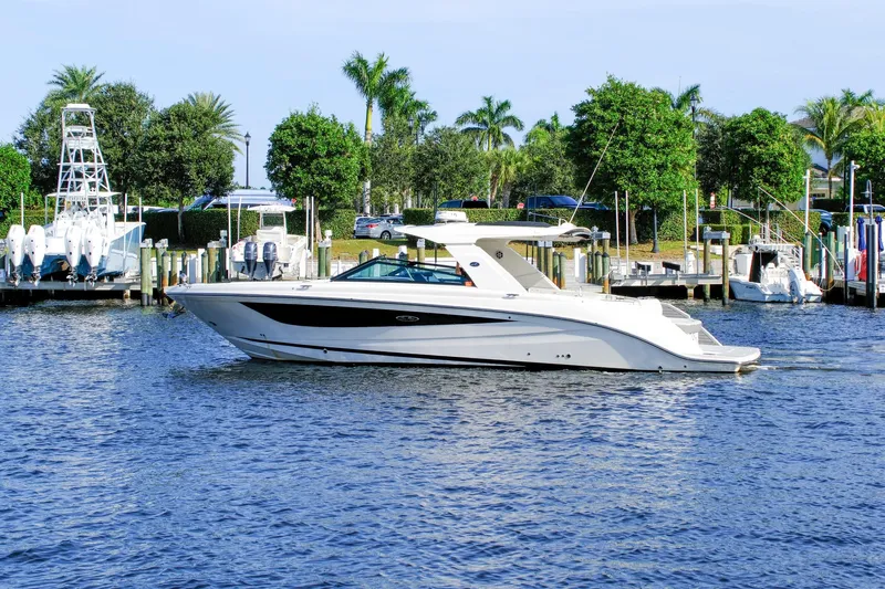 Sensei I Yacht Photos Pics 2021 Sea Ray SLX 400 boat docked in a marina with lush greenery.