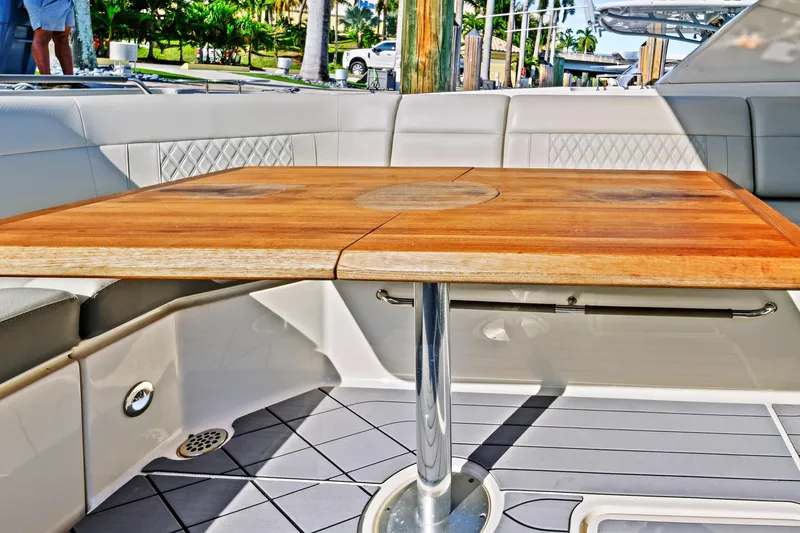 Sensei I Yacht Photos Pics Luxury seating area on 2021 Sea Ray SLX 400 boat with wooden table and cushioned seats.