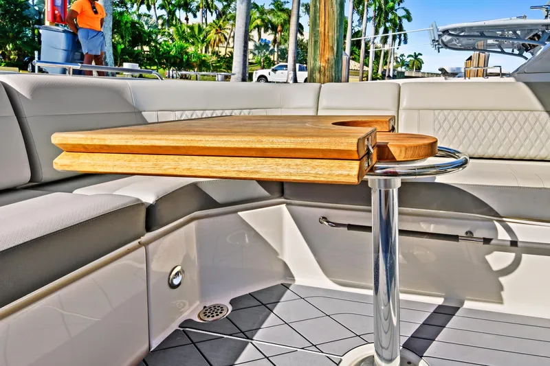 Sensei I Yacht Photos Pics 2021 Sea Ray SLX 400 yacht interior with wooden table and cushioned seating.